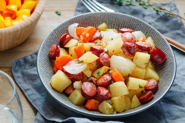 Pieczone kiełbaski z warzywami np. cebulą ziemniaczaną i marchewką Łatwy szybki przepis na obiad lub lunch