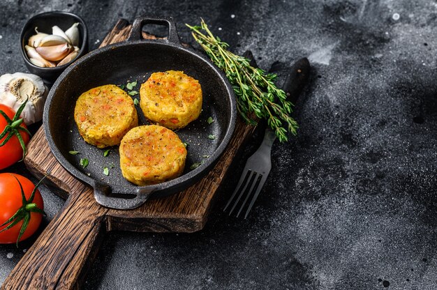 Pieczone kotleciki warzywne do wegańskich burgerów. Ciemne tło.