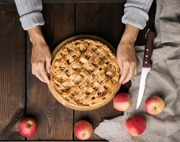 Pieczone Okrągłe Ciasto Z Jabłkami Na Drewnianym Brązowym Stole Dwie Kobiece Dłonie