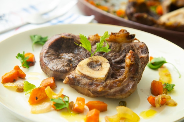 Pieczone Ossobuco gotowane w niskiej temperaturze na łożu z warzyw i ziemniaków