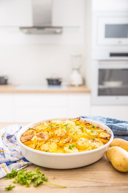 Pieczone ziemniaki z przyprawami i ziołami na stole w kuchni.