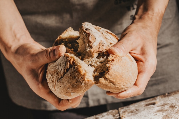 Piekarz lub szef kuchni trzyma świeży chleb