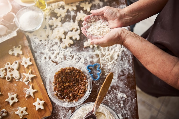 Piekarz z garścią mąki przy kuchennym stole