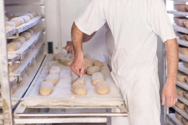 Zdjęcie piekarze przygotowujący ciasto na produkty w tradycyjnej piekarni