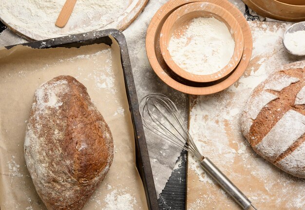 Zdjęcie piekły chleb na stole i składniki naczynia kuchenne leżą w pobliżu widok z góry