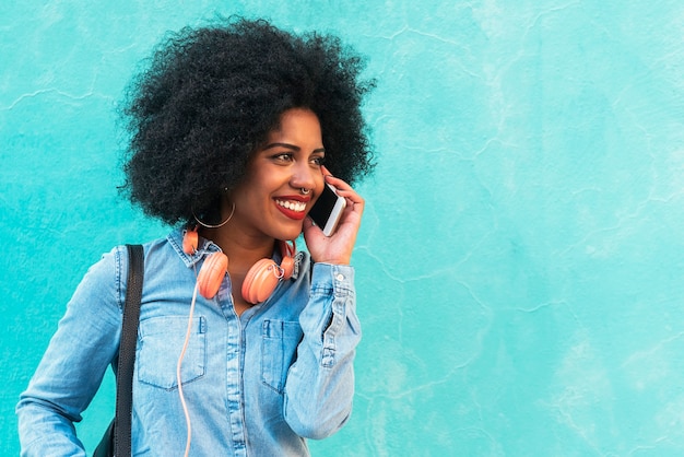 Piękna afro amerykańska kobieta za pomocą telefonu komórkowego na ulicy. Koncepcja komunikacji.