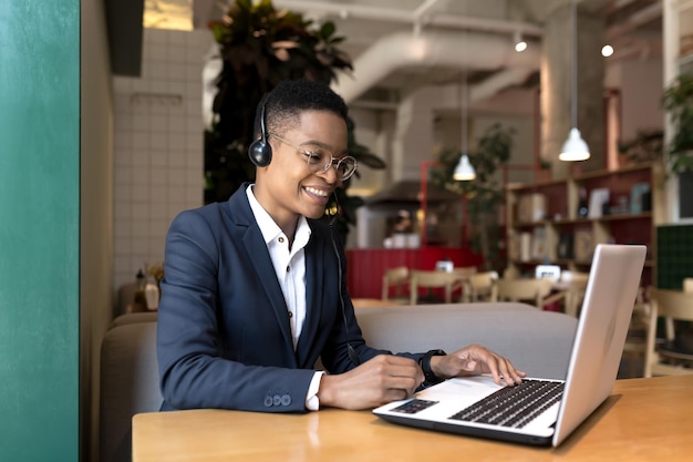 Piękna Afroamerykanka Patrząca Na Kamerę I Uśmiechnięta Pracująca W Coworkingowej Kawiarni Komunikacji Wideo Za Pomocą Zestawu Słuchawkowego Biznes Kobieta Freelancer