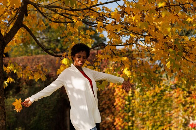 Piękna Afroamerykanka spacerująca po jesiennym ogrodzie
