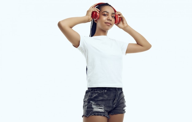 Piękna afrykańska nastoletnia dziewczyna z dreadlocks w sportswear słuchającej muzyce