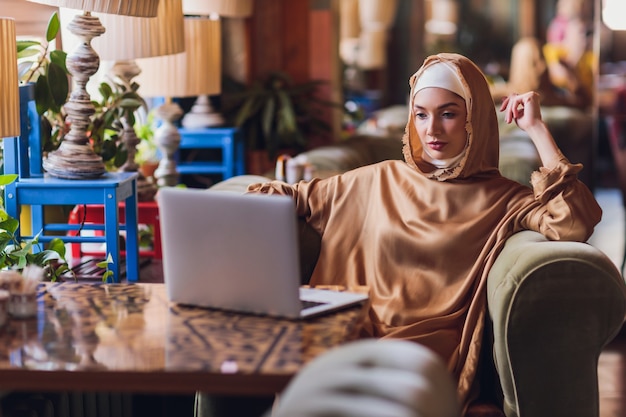 Piękna arabska biznesowa kobieta pracuje na komputerze.