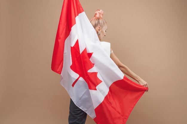 Zdjęcie piękna azjatka, fanka sportu, stojąca przed kanadyjską flagą