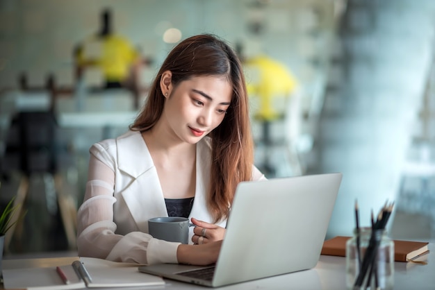 Piękna Azjatycka Bizneswoman Lub Kierownik Finansowy Pracujący W Nowoczesnym Biurze Na Laptopie