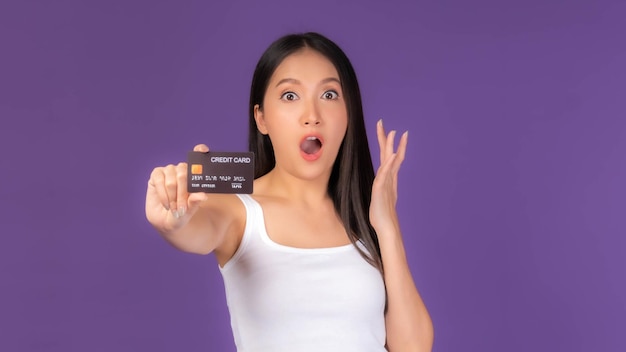 Piękna Azjatycka brunetka kobieta ładna dziewczyna w białym podkoszulku Podekscytowana zdziwiona dziewczynapokazuje kartę kredytową do płatności zakupy online karta kredytowa zakupy online koncepcja telemarketingu e-commerce