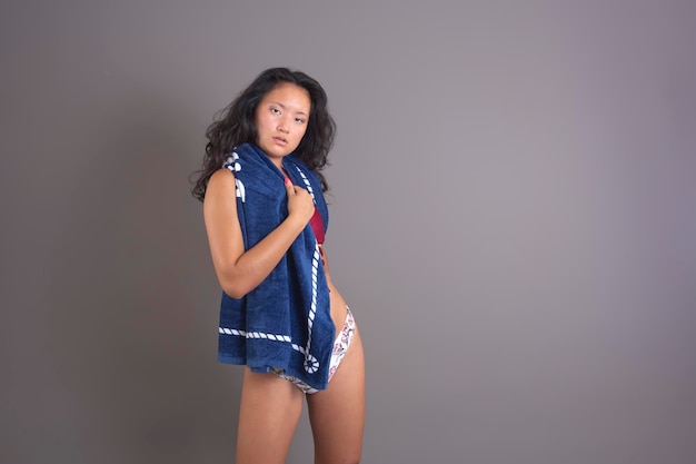Piękna azjatycka etniczna kobieta w bikini z ręcznikiem na szyi