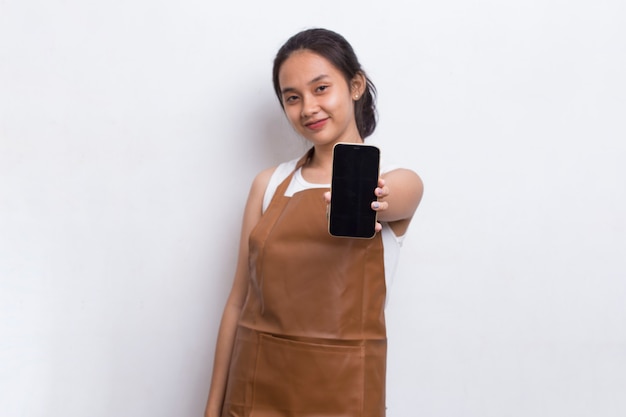Piękna azjatycka kelnerka Barista demonstruje telefon komórkowy na białym tle