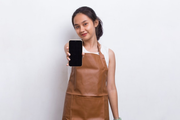 Piękna azjatycka kelnerka Barista demonstruje telefon komórkowy na białym tle