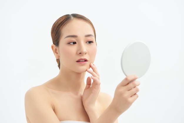 Piękna Azjatycka kobieta sprawdzająca jej pielęgnację skóry leczenie trądziku Koncepcja spa i pielęgnacji skóry