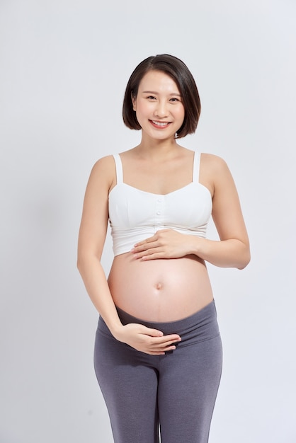 Piękna Azjatycka kobieta, stojąca dotykając jej brzucha. Koncepcja ciąży i oczekiwania
