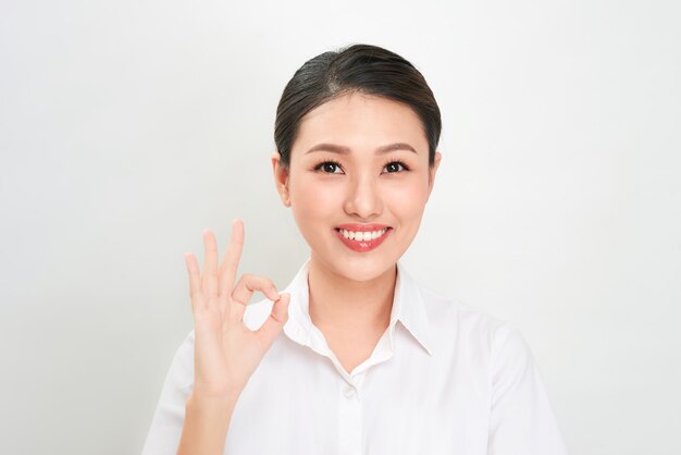 Piękna Azjatycka Kobieta Uśmiecha Się I Pokazuje Znak Ok. Prezentacja Twojego Produktu.