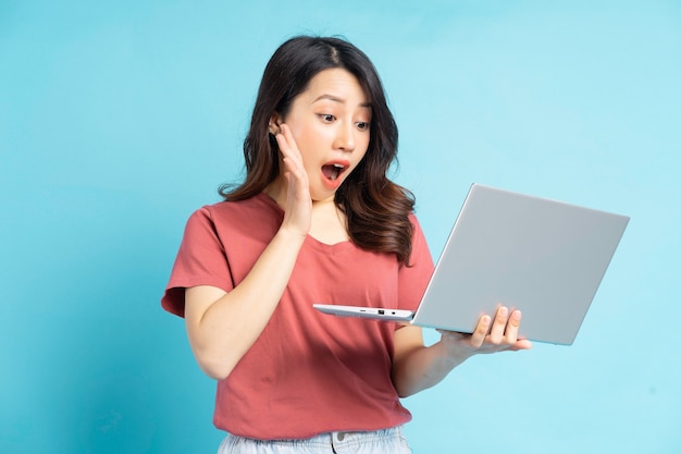 Piękna Azjatycka kobieta za pomocą laptopa z zdziwioną twarzą