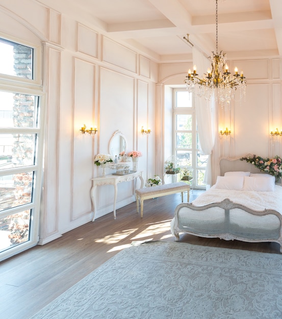 Zdjęcie piękna biała, jasna, czysta sypialnia w luksusowym stylu barokowym.