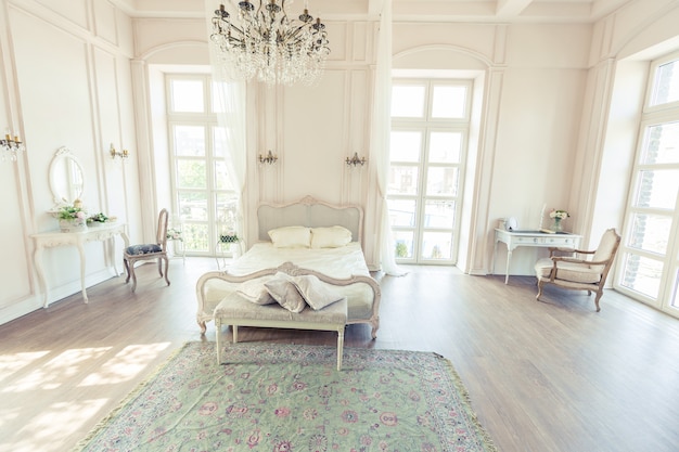 Piękna biała, jasna, czysta sypialnia w luksusowym stylu barokowym.
