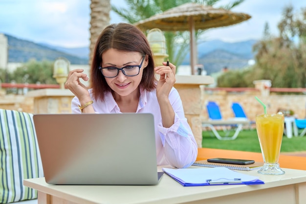 Piękna biznesowa kobieta po czterdziestce pracująca zdalnie na laptopie