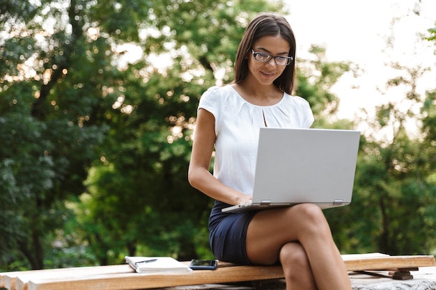 Piękna biznesowa kobieta za pomocą laptopa na zewnątrz