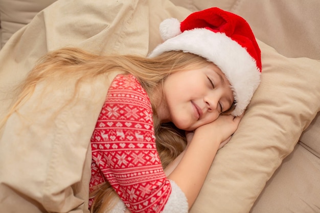 Piękna Blondynka W Czapce świętego Mikołaja I Noworocznej Piżamie śpi W łóżku