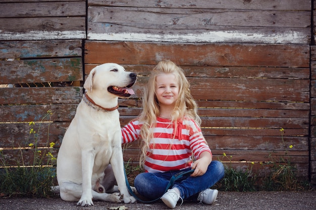 Piękna blondynki dziewczyna bawić się z jej psem. Portret na zewnątrz. seria