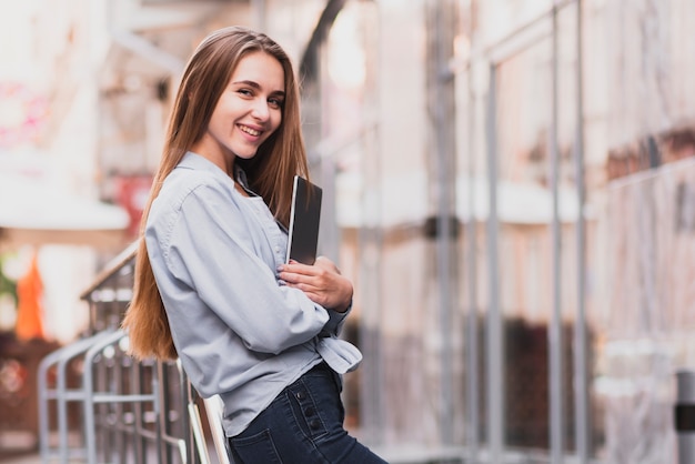 Zdjęcie piękna blondynki kobieta odpoczywa na poręczu