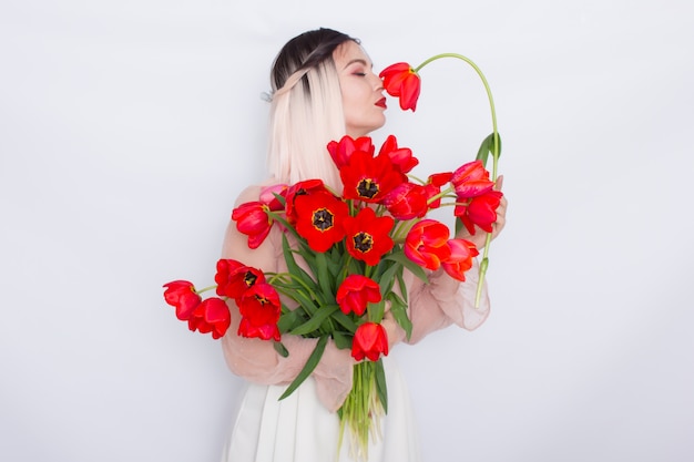 Piękna blondynki kobieta z czerwonymi tulipanami