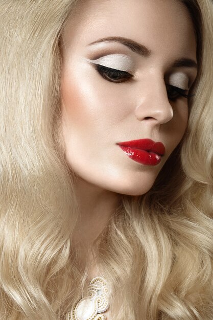 Piękna blondynki kobieta z wieczór makijażem i czerwonymi wargami