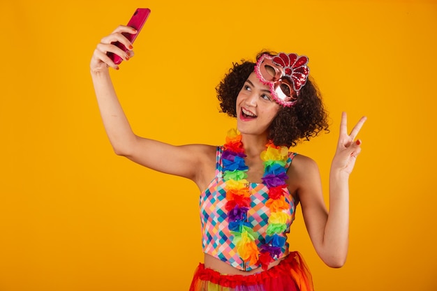 Piękna brazylijska kobieta ubrana w karnawałowe ubrania biorąc autoportret ze smartfonem