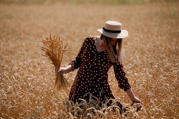 Piękna brunetka plus size pani w polu pszenicy o zachodzie słońca.