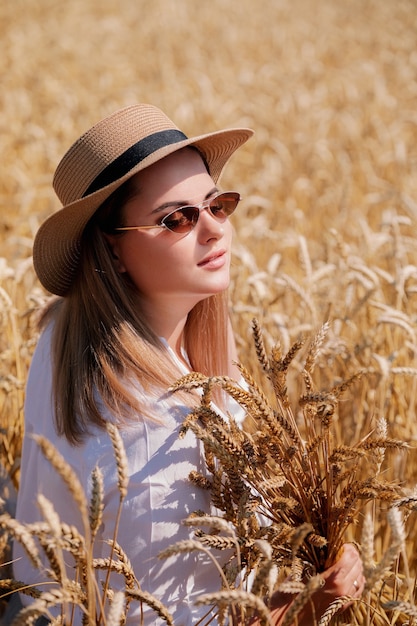 Piękna brunetka plus size pani w polu pszenicy o zachodzie słońca.