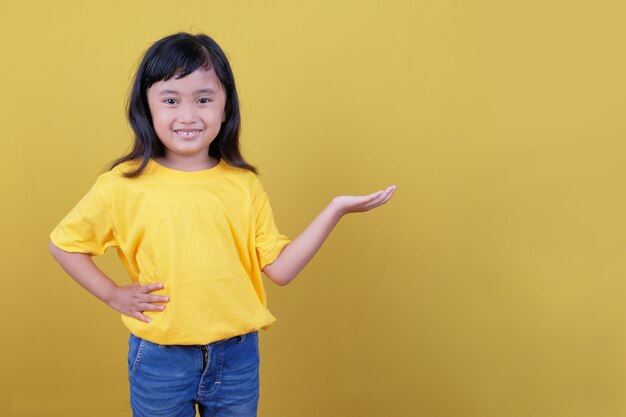 Piękna czarnowłosa dziewczyna w żółtej koszulce, coś pokazując