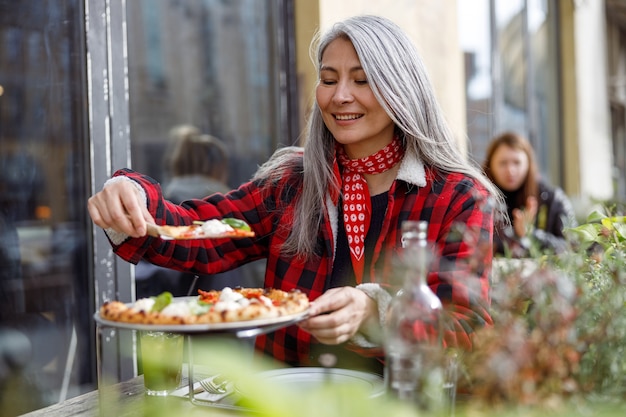 Piękna Dojrzała Azjatycka Kobieta Je Pizzę Na Tarasie Kawiarni