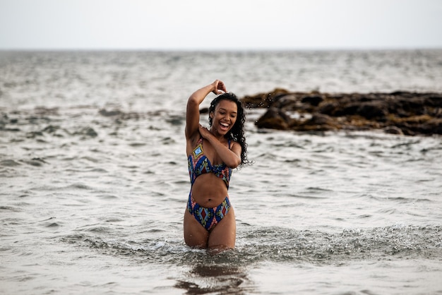 Piękna dopasowana figlarna czarna kobieta w bikini na wulkanicznej plaży w Santo Antao, Wyspy Zielonego Przylądka