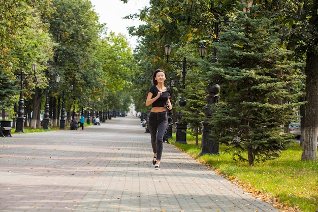 Piękna dziewczyna azjatyckich jogging w parku latem