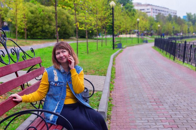 Piękna dziewczyna idzie ulicą i rozmawia przez telefon