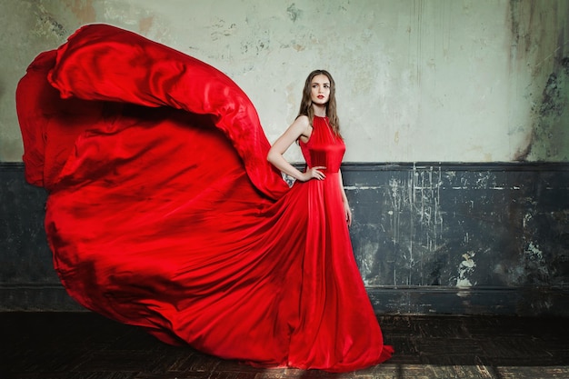 Zdjęcie piękna dziewczyna moda ubrana w czerwoną suknię wieczorową na tle vintage