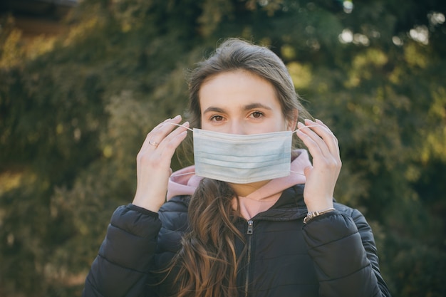 Piękna dziewczyna nosi maskę medyczną podczas epidemii koronawirusa COVID-19. Koncepcja życia i bezpieczeństwa życia, koronawirus N1H1, ochrona przed wirusami