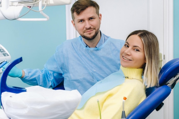 Zdjęcie piękna dziewczyna pacjentka siedzi w gabinecie dentystycznym w recepcji i obok lekarza