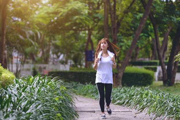 piękna dziewczyna pasuje zrelaksowany bieganie i bieganie na ulicy z naturą. Relaksujący czas i