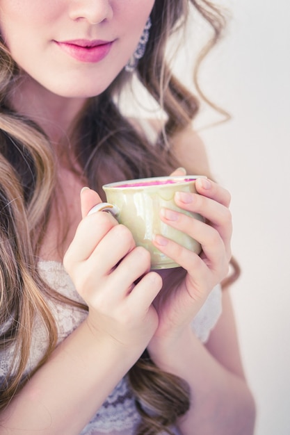 Piękna dziewczyna picia gorącej kawy rano na białym tle.