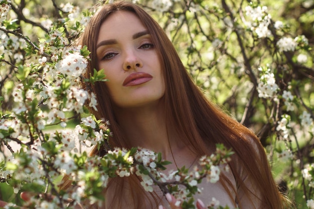 Piękna dziewczyna pozuje w ogródzie okwitnięcia wiśni