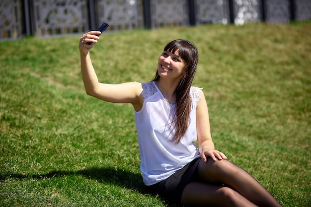 Piękna dziewczyna robi selfie na smartfonie.