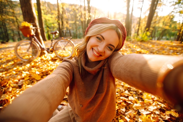 Piękna dziewczyna robi selfie w jesiennym parku