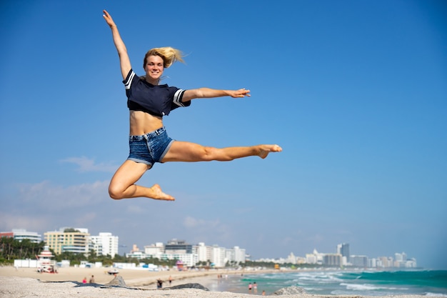 Piękna Dziewczyna Skacze Z South Beach W Tle, Miami Beach. Floryda. Pojęcie Szczęścia I Wolności.